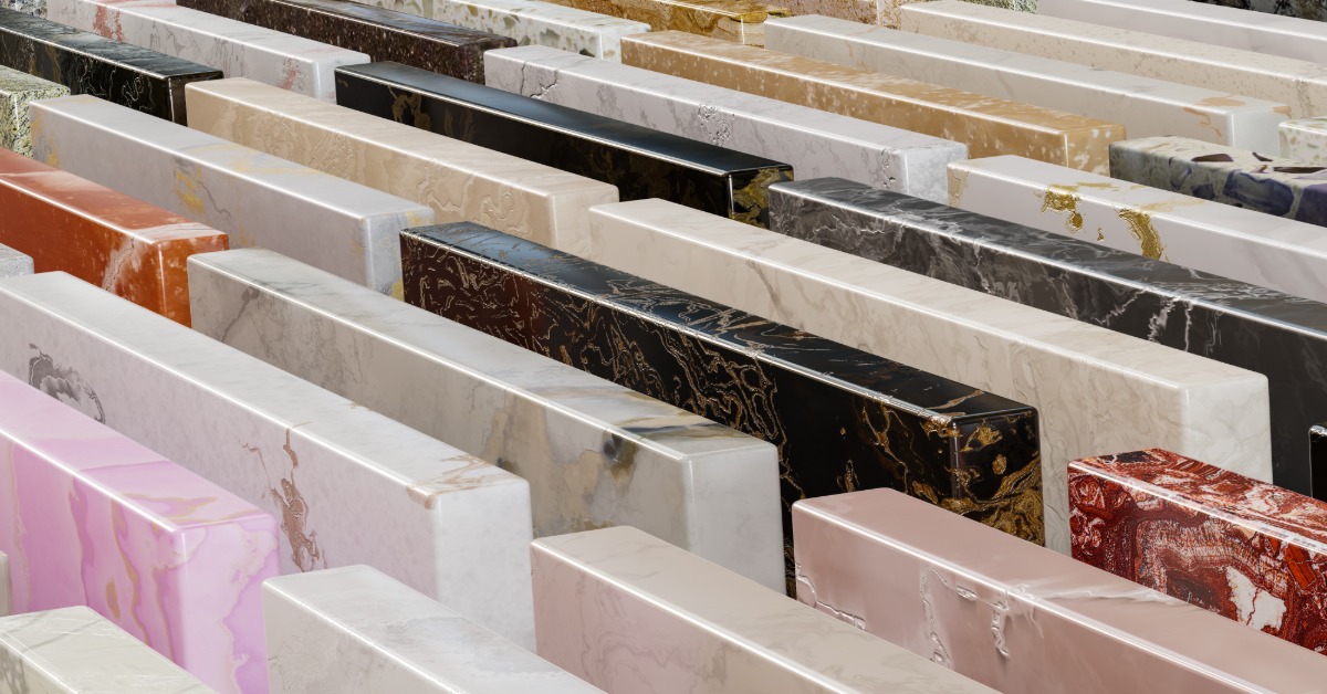 Several granite samples are neatly lined up in rows. Each slab is a different color, including white, pink, red, black, and gold.