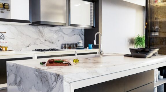 A modern kitchen with quartz countertops and the same quartz backsplash. The kitchen island quartz features a waterfall design.